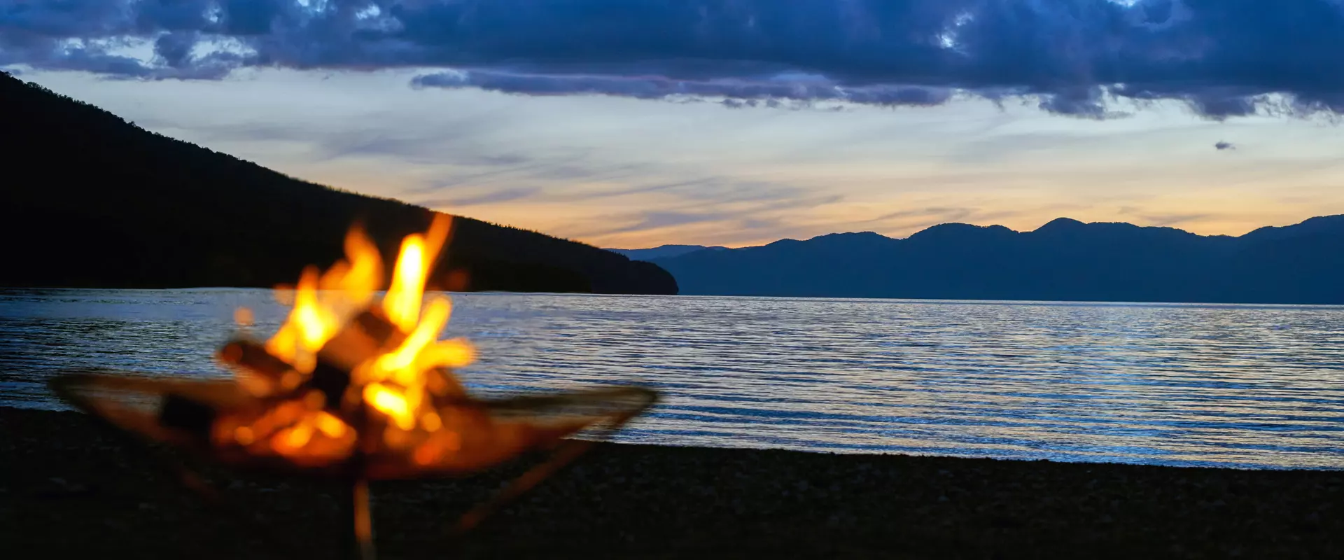 Bonfire over the water at dusk